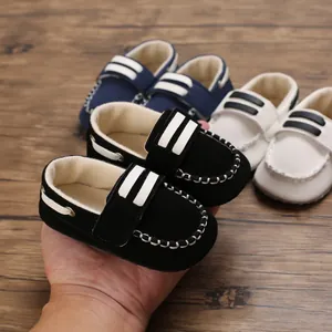 Nahaufnahme von weichen Baby-Loafers mit Klettverschluss und weißen Streifendetails.