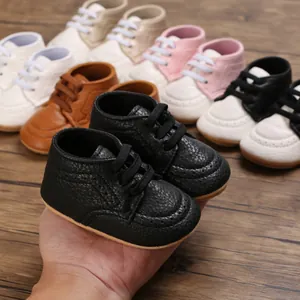 Detail view of black textured leather infant walking shoes with soft rubber soles.