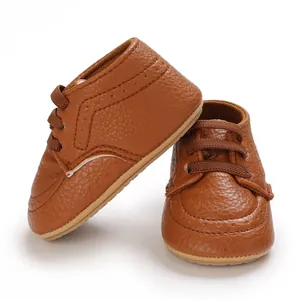 Detailed view of brown faux leather baby walking shoes with lace-up design and soft sole