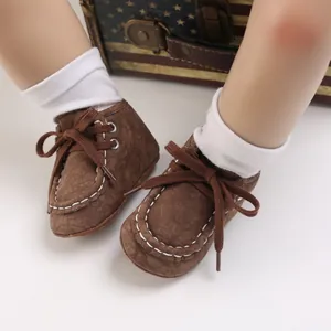 Detailansicht brauner Baby-Lauflernschuhe mit Schnürung und weißen Ziernähten.