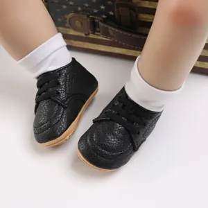 Close-up view of black textured faux leather baby walking shoes with soft rubber soles