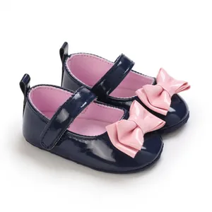 Detailansicht der dunkelblauen Baby-Mary-Janes mit rosa Schleifen aus Lackleder
