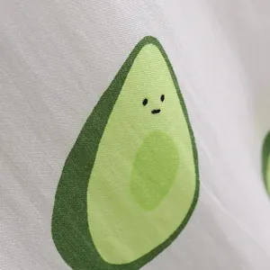 Close-up detail of a men's summer beach shirt featuring a cute cartoon avocado print.