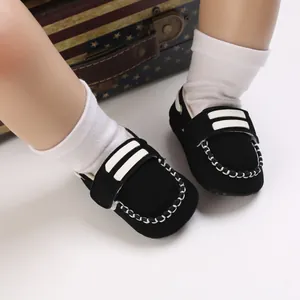 Primer plano de zapatos negros para caminar para bebés con suela blanda y costuras