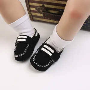 Vista detallada de zapatos para caminar de bebé en ante negro con costuras blancas