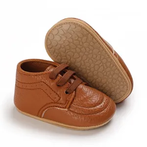 Detailed view of brown infant walker shoes featuring pebble-textured soft rubber soles