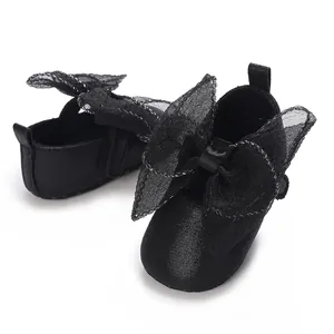 Nahaufnahme von eleganten schwarzen Baby-Prinzessin-Schuhen mit einer großen Netzschleife