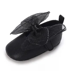 Detailansicht eines schwarzen Baby-Lauflernschuhs mit einer eleganten großen Spitzenschleife