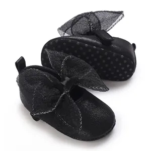 Detailansicht schwarzer Baby-Lauflernschuhe mit Schleifen und rutschfester Gummisohle.