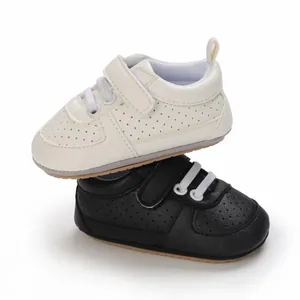 Vista detallada de zapatillas para bebé blancas y negras con suelas flexibles