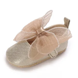 Detaillierte Nahaufnahme goldene Glitzer-Babyschuhe für Mädchen mit einer großen Mesh-Schleife
