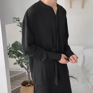 Vista laterale dettagliata di una camicia nera minimalista a maniche lunghe vestibilità comoda