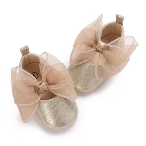 Detailansicht von champagnergoldenen Baby-Lernlaufschuhen mit großer Organza-Schleife