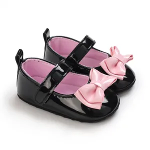 Nahaufnahme glänzende schwarze Lack-Babyschuhe für Mädchen mit rosa Schleife