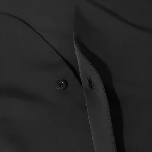 Primo piano di un classico bottone nero e della trama del tessuto su una camicia
