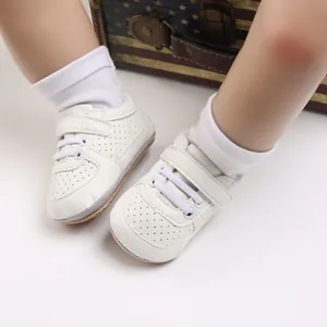 Vista detallada de zapatos blancos para primeros pasos con suela blanda y velcro para bebés