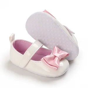 Detailansicht cremefarbener Babyschuhe für Mädchen mit rutschfester Sohle und rosa Schleife.