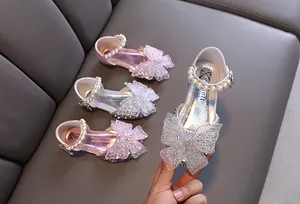 Primer plano de zapatos de princesa para niña con lazos de strass y correas de perlas