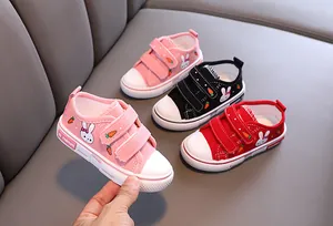 Gros plan de chaussures en toile pour enfants avec de mignons motifs de lapin et carotte