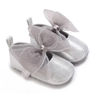 Detailansicht der silbernen Baby-Prinzessin-Schuhe mit großer Organza-Schleife und Glitzer