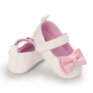 Detailansicht eleganter cremefarbener Babyschuhe für Mädchen mit rosa Schleifen und weichen Sohlen