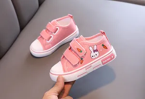 Détail de chaussures en toile roses pour tout-petits avec motif lapin et scratchs