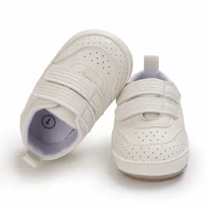 Dettaglio ravvicinato di scarpe da camminata bianche per neonati con doppio velcro