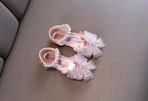 Vista detallada de zapatos de princesa rosa para niñas con lazos de malla y perlas finas.