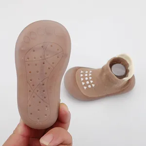 Detalle de la suela de goma suave antideslizante para zapatos de bebé marrones transpirables.