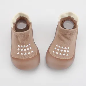 Detalle de zapatos calcetín para bebé en marrón con suelas blandas antideslizantes