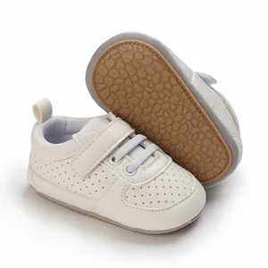 Vista detallada de zapatos de bebé blancos con suela de goma antideslizante