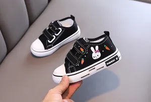 Détail de la chaussure en toile noire pour enfant avec un motif lapin et velcro