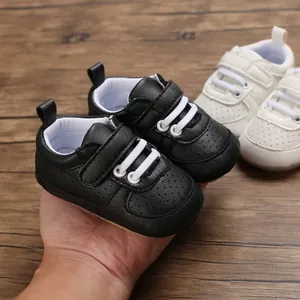 Primer plano detallado de zapatos negros para bebé con suela blanda y cierre de velcro