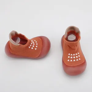 Vista detallada de calcetines zapato naranjas para bebé con suelas suaves antideslizantes.
