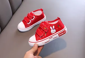 Détail de chaussures en toile rouges pour enfants avec motif lapin et velcro