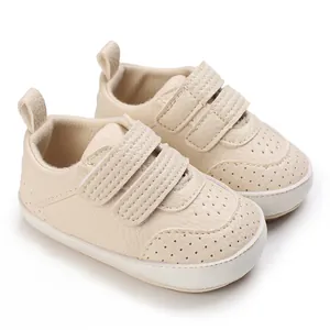 Primo piano di scarpe primi passi beige per neonati con chiusura a strappo