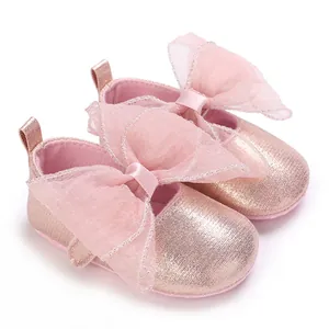 Nahaufnahme der glitzernden rosa Babyschuhe mit großer Schleife und weicher Sohle.