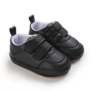 Dettaglio scarpe neonato in pelle PU nera con suola morbida e chiusura a strappo
