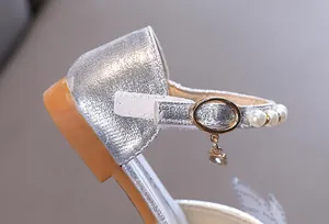 Primer plano detallado de zapato de princesa plateado para niña con correa de perlas