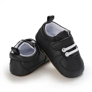 Detalle de zapatos negros para primeros pasos de bebé con suelas de goma blandas