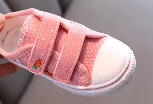 Vue détaillée de la chaussure en toile rose pour enfant avec broderie de carotte