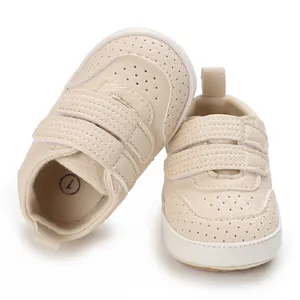 Dettaglio di scarpe da camminata per neonati in PU beige con fori e chiusura a strappo