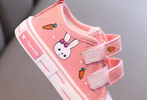 Gros plan de chaussures en toile roses avec broderie lapin et carotte