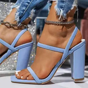 Gros plan de sandales bleu clair à bout carré avec brides texturées et talons hauts.