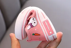 Gros plan de chaussure en toile souple pour enfant avec broderie de lapin rose mignon.