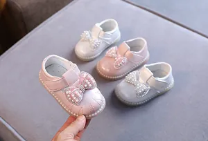 Detailansicht von Prinzessinnenschuhen für Mädchen mit Perlenbögen und weichen Sohlen in Pink.