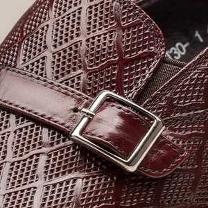 Gros plan de la chaussure en cuir de veau gaufré bordeaux avec boucle métallique