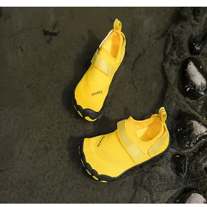 Vibrant yellow outdoor water shoes for swimming and hiking on wet rocky terrain area