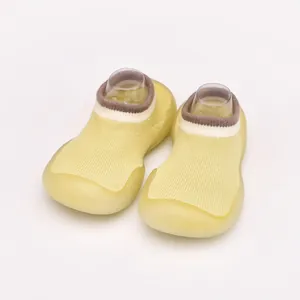 Detailed macro view of breathable yellow knit baby sock shoes with a flexible soft rubber sole