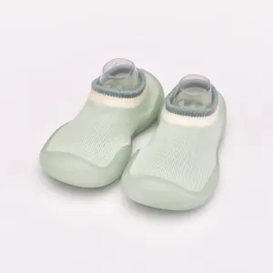 Detail view of breathable baby sock shoes with light green knit and flexible soft sole.